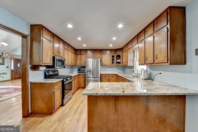 3615 Miller Bottom Rd, Loganville, GA 30052 - kitchen featuring sink, light hardwood / wood-style flooring, light stone counters, kitchen peninsula, and stainless steel appliances