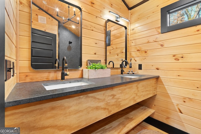 bathroom featuring vanity, lofted ceiling, wooden walls, a notable chandelier, and wood-type flooring