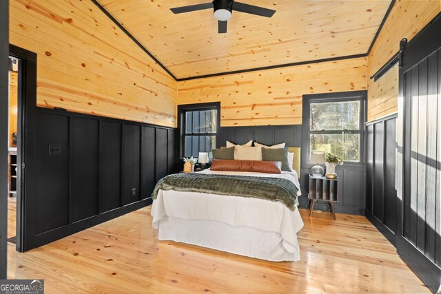 73 Cannon St, Clayton, GA 30525 - bedroom featuring lofted ceiling, wood ceiling, a barn door, light wood-style flooring, and wood walls