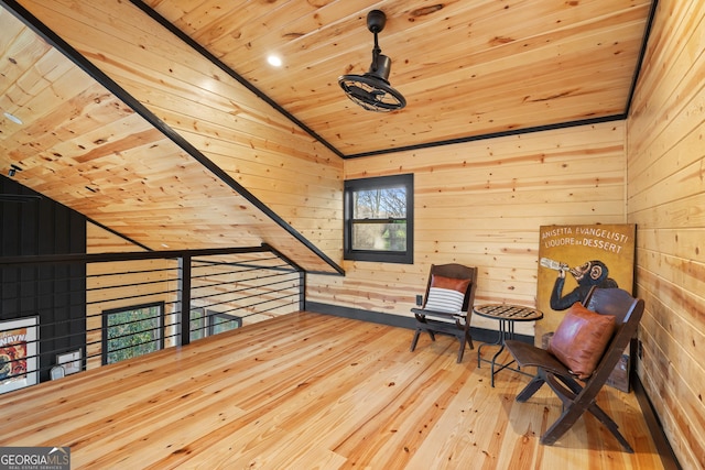 sitting room with wood walls, wood-type flooring, lofted ceiling, and wood ceiling