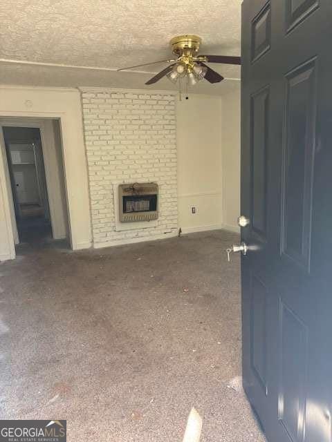 unfurnished living room featuring heating unit, carpet floors, and a textured ceiling