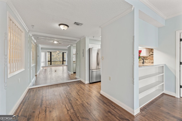 corridor with dark hardwood / wood-style floors, crown molding, and a textured ceiling