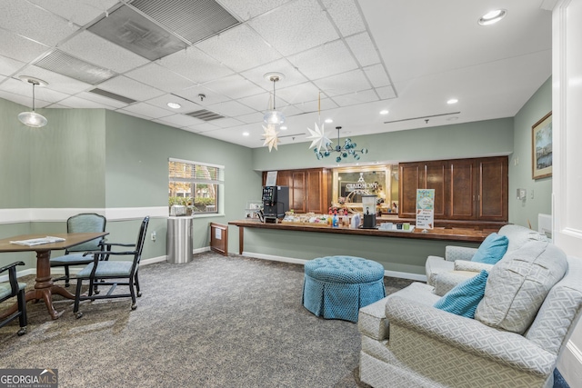 interior space featuring a paneled ceiling, carpet floors, and decorative light fixtures