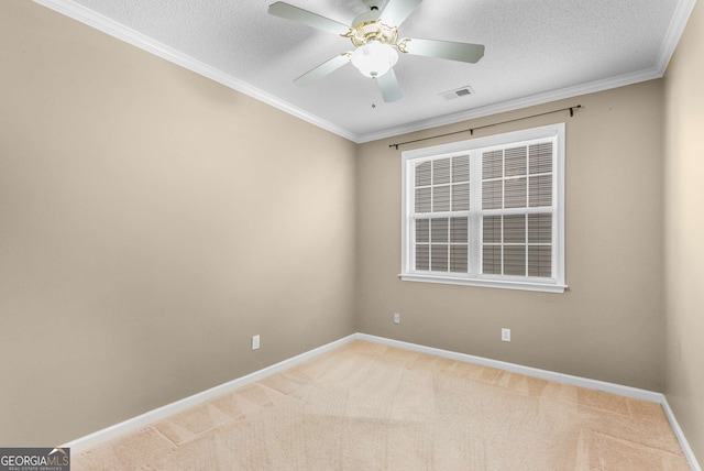 empty room featuring a textured ceiling, carpet floors, ceiling fan, and ornamental molding