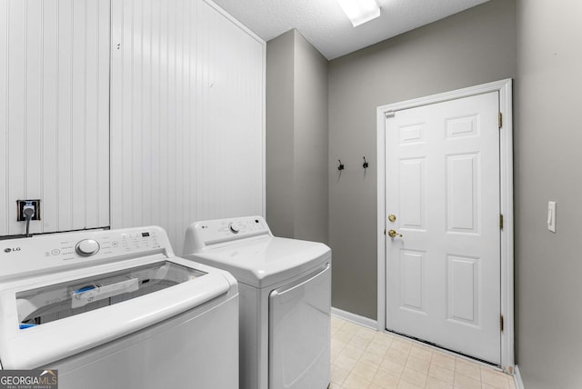 washroom with a textured ceiling and washing machine and clothes dryer