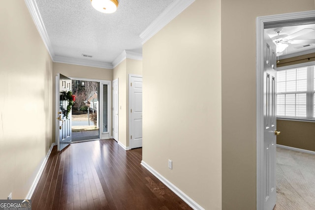 hallway featuring ornamental molding, a textured ceiling, dark hardwood / wood-style flooring, and a healthy amount of sunlight