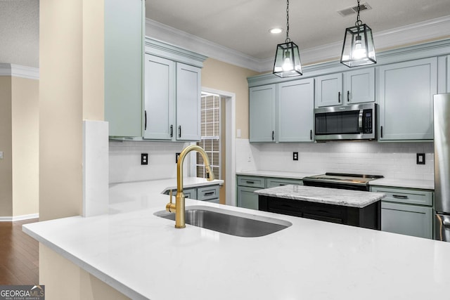 kitchen featuring backsplash, sink, decorative light fixtures, and appliances with stainless steel finishes