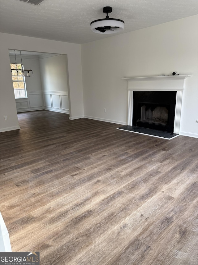 unfurnished living room with hardwood / wood-style floors, ceiling fan, and a textured ceiling