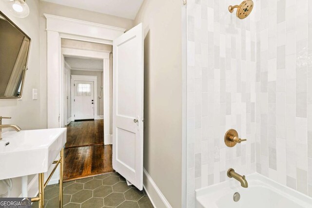 bathroom with tiled shower / bath combo and wood-type flooring