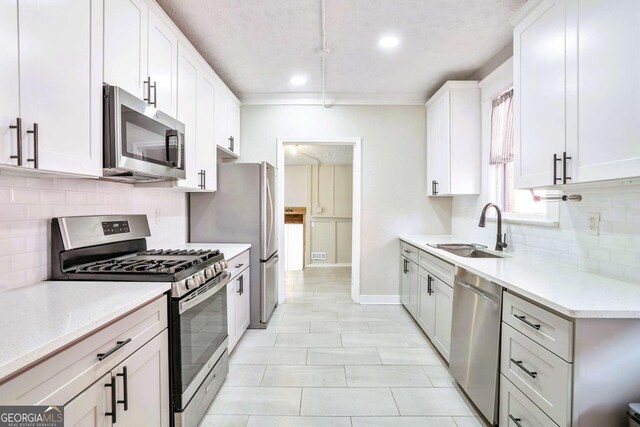 kitchen with white cabinets, sink, a textured ceiling, tasteful backsplash, and stainless steel appliances