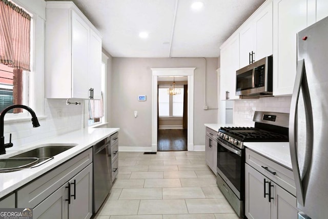 kitchen with white cabinets, appliances with stainless steel finishes, a healthy amount of sunlight, and sink