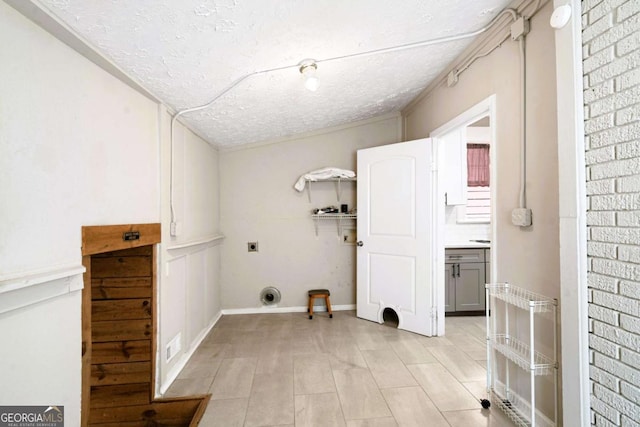 laundry room featuring hookup for an electric dryer and a textured ceiling