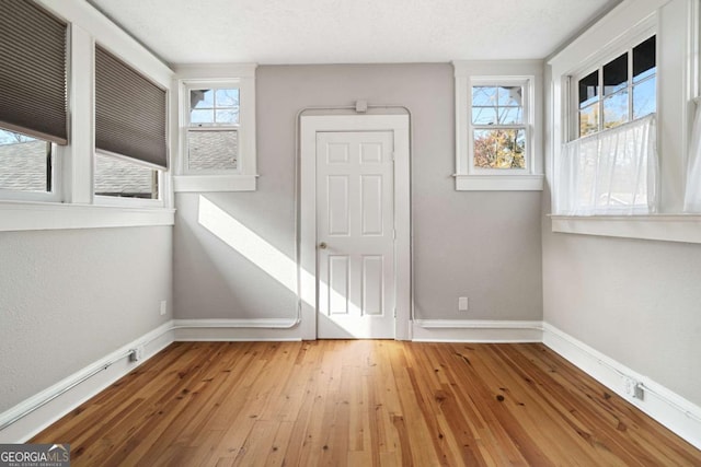 spare room featuring light hardwood / wood-style flooring and a textured ceiling