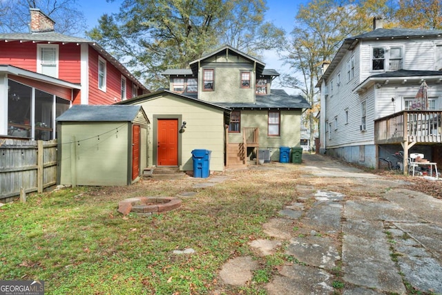 rear view of house with a fire pit and a sunroom