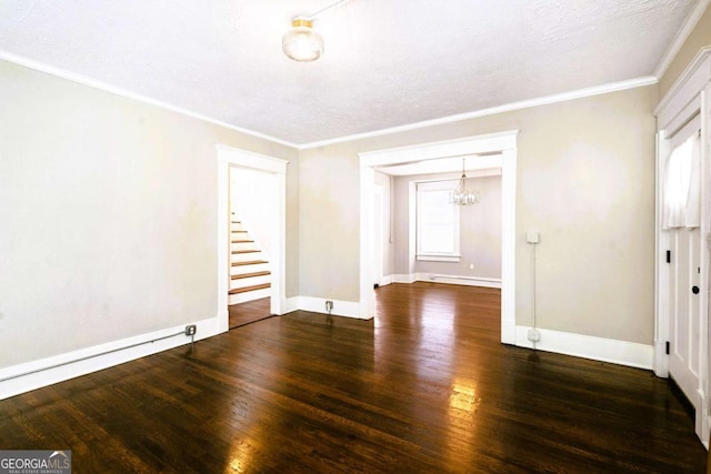 spare room featuring a baseboard heating unit, crown molding, dark hardwood / wood-style floors, a textured ceiling, and a chandelier