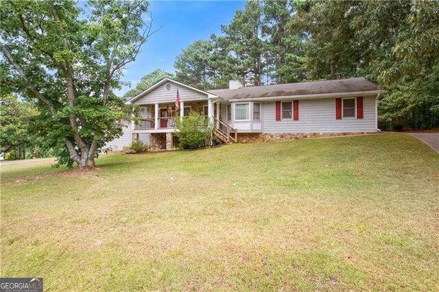 ranch-style home featuring a porch and a front lawn