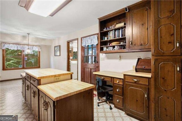 kitchen with butcher block counters, a center island, pendant lighting, and washer / dryer