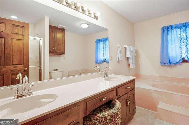 bathroom featuring tile patterned flooring, vanity, and shower with separate bathtub