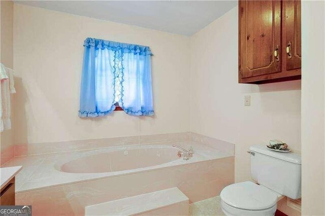 bathroom featuring a tub to relax in, vanity, and toilet