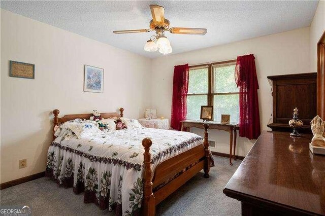 bedroom with ceiling fan, carpet floors, and a textured ceiling