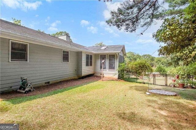 rear view of property with a yard