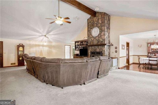 carpeted living room featuring ceiling fan, a fireplace, beamed ceiling, and high vaulted ceiling