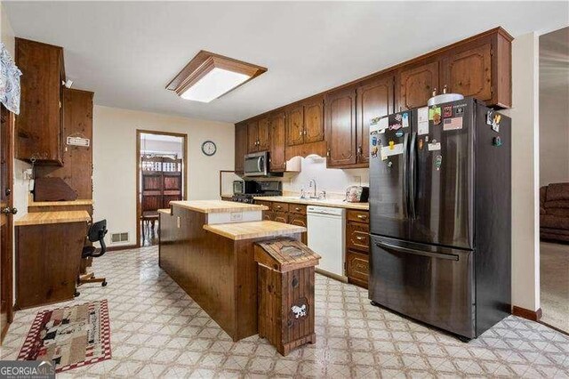 kitchen featuring butcher block countertops, a center island, and appliances with stainless steel finishes