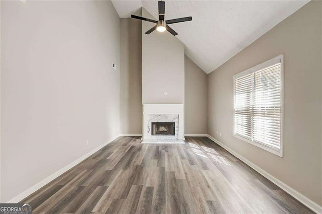 unfurnished living room featuring a fireplace, hardwood / wood-style floors, high vaulted ceiling, and ceiling fan