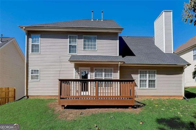 rear view of house featuring a deck and a lawn