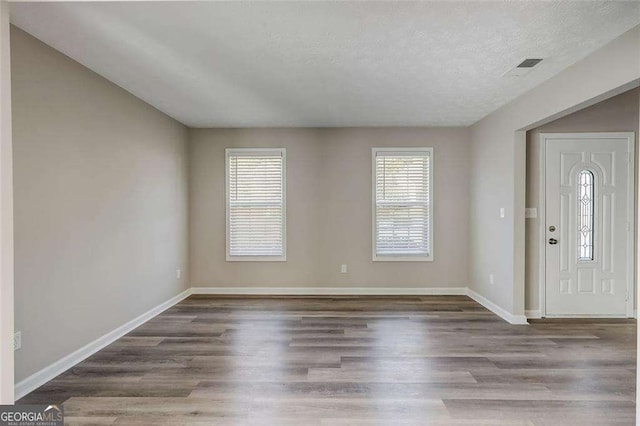 entryway with wood-type flooring and a textured ceiling