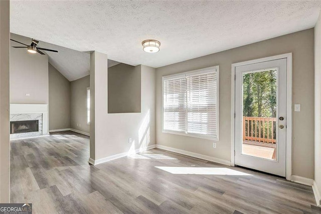 interior space featuring a textured ceiling, light hardwood / wood-style flooring, and a healthy amount of sunlight