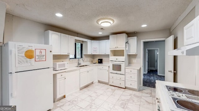 kitchen featuring white cabinets, a textured ceiling, white appliances, and sink