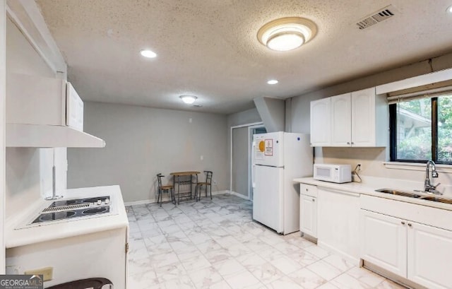 kitchen with a textured ceiling, white cabinetry, white appliances, and sink