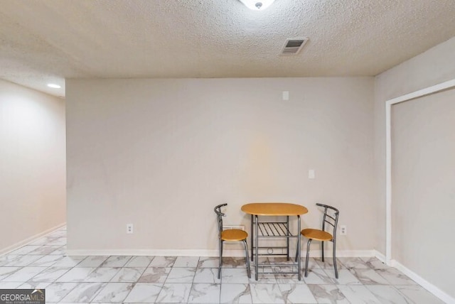 dining space featuring a textured ceiling