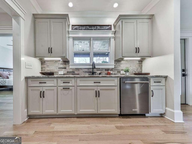 kitchen featuring light wood-type flooring, gray cabinets, stainless steel dishwasher, and tasteful backsplash