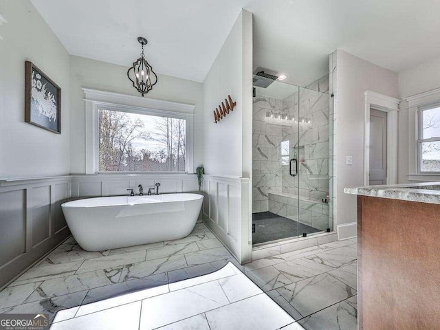 bathroom featuring vanity, a chandelier, and shower with separate bathtub