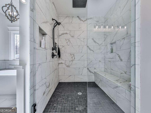 bathroom featuring a notable chandelier and tiled shower