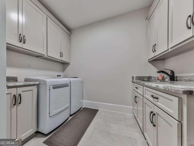 clothes washing area featuring cabinets, independent washer and dryer, light tile patterned floors, and sink