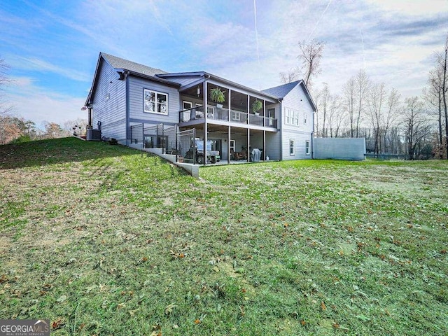 rear view of property with a sunroom and a yard