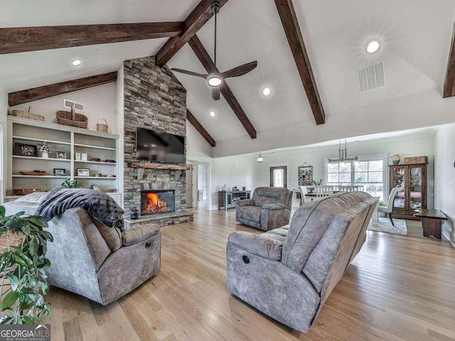 living room with beam ceiling, a stone fireplace, high vaulted ceiling, and light hardwood / wood-style flooring