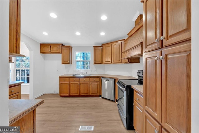 kitchen with sink, light hardwood / wood-style flooring, stainless steel dishwasher, black / electric stove, and custom range hood