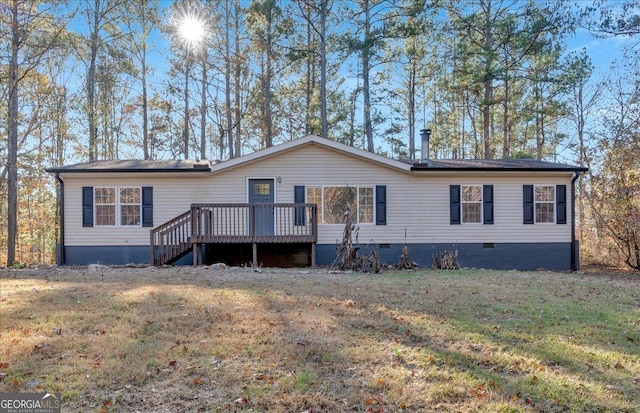 rear view of property with a deck and a lawn