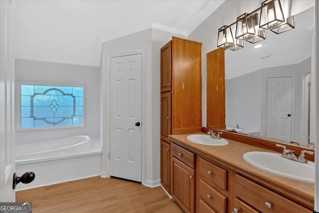 bathroom with hardwood / wood-style flooring, vanity, a bathing tub, and crown molding