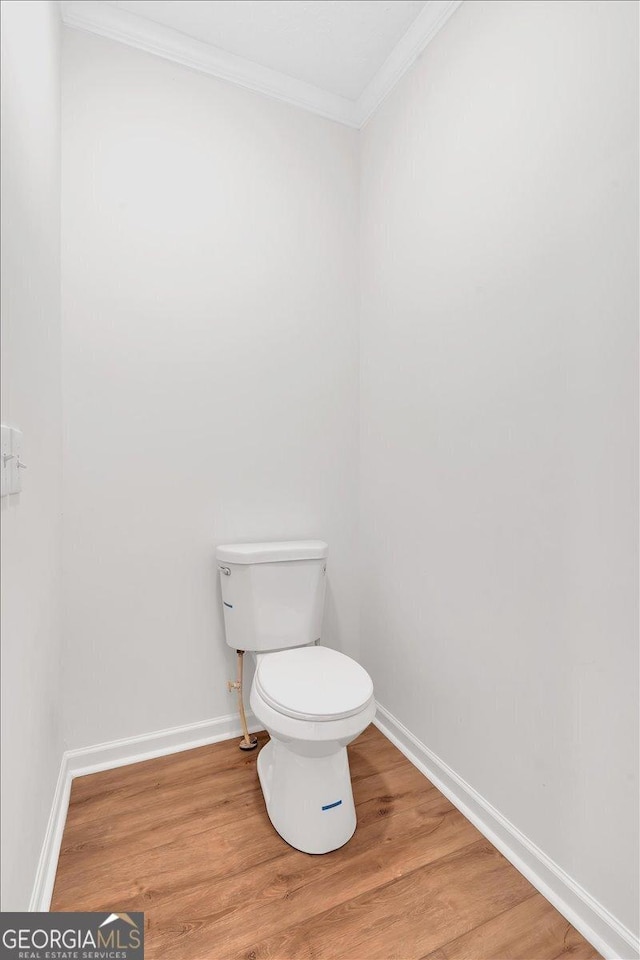 bathroom with ornamental molding, wood-type flooring, and toilet