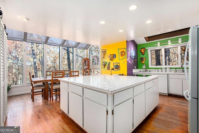 kitchen featuring sink, a kitchen island, light hardwood / wood-style flooring, white appliances, and white cabinets