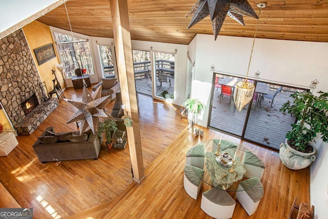 living room with a fireplace, hardwood / wood-style floors, high vaulted ceiling, and wooden ceiling