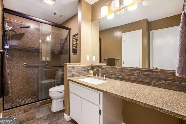 bathroom with decorative backsplash, toilet, a shower with shower door, and vanity