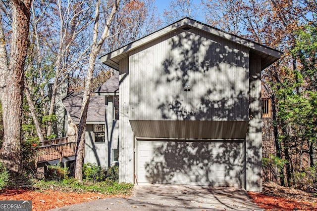 view of property exterior featuring a garage and a wooden deck