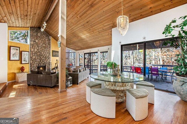 living room with beamed ceiling, high vaulted ceiling, wood-type flooring, and wood ceiling