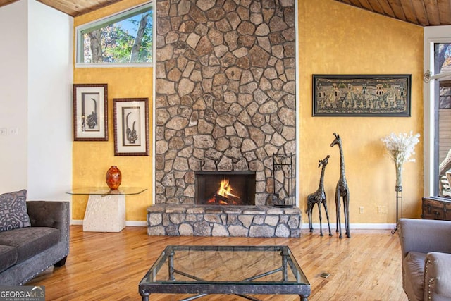 living room featuring a fireplace, hardwood / wood-style floors, vaulted ceiling, and wooden ceiling